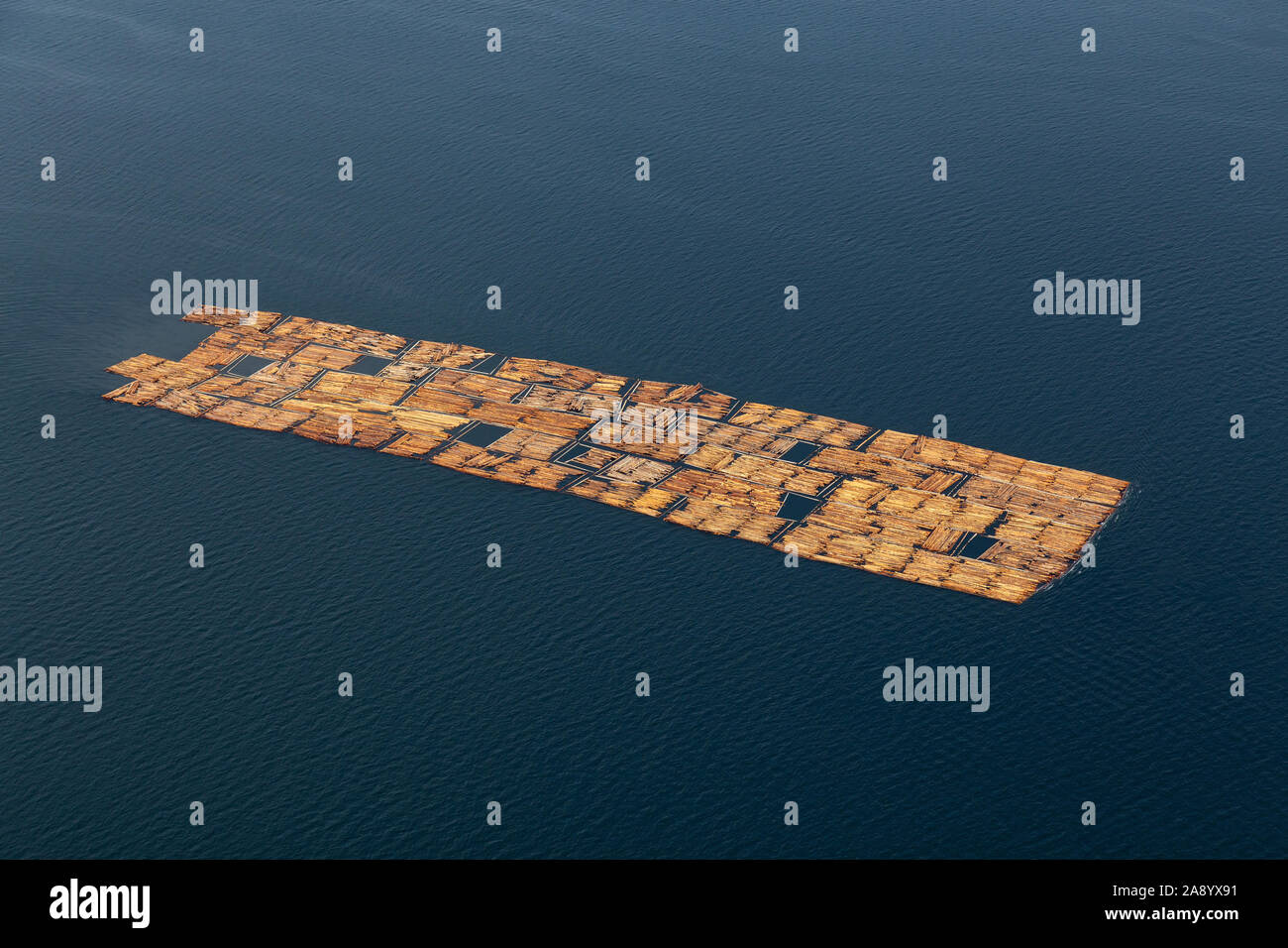 Aerial View of Tugboat towing Lumber in the ocean during a hazy summer day. Taken in Sunshine Coast, BC, Canada. Stock Photo