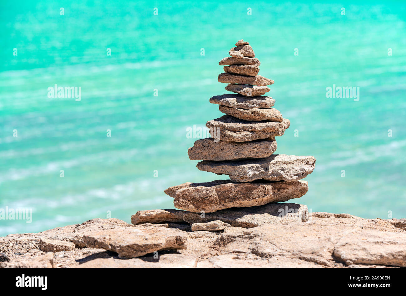 A wish stone pyramid by the Laguna Verde (green lagoon) with its turquoise green waters by the Uyuni salt flat, Bolivia. Stock Photo