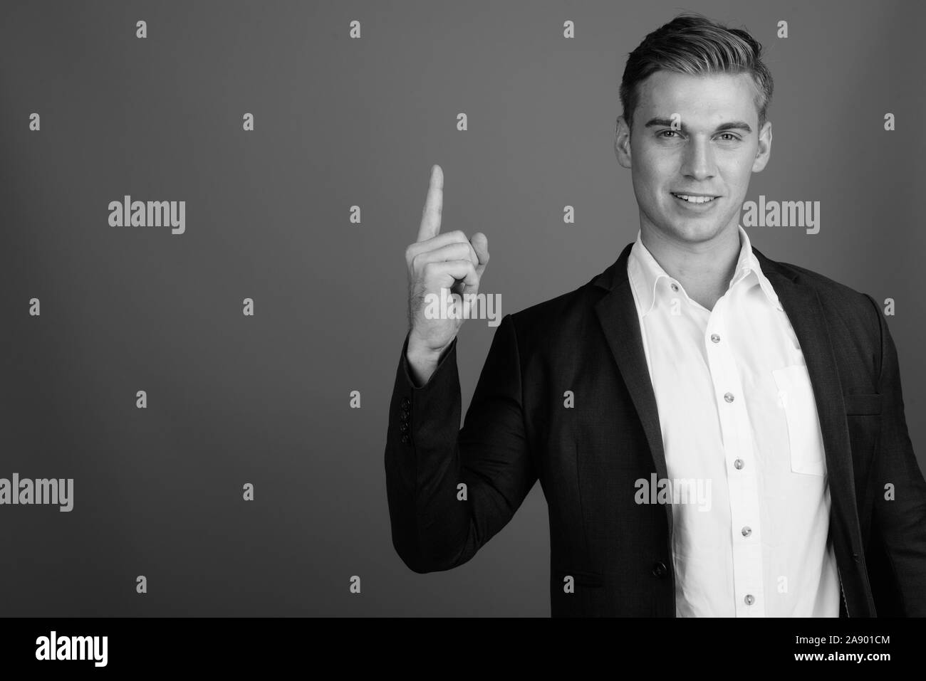 Portrait of young handsome businessman wearing suit in black and white ...