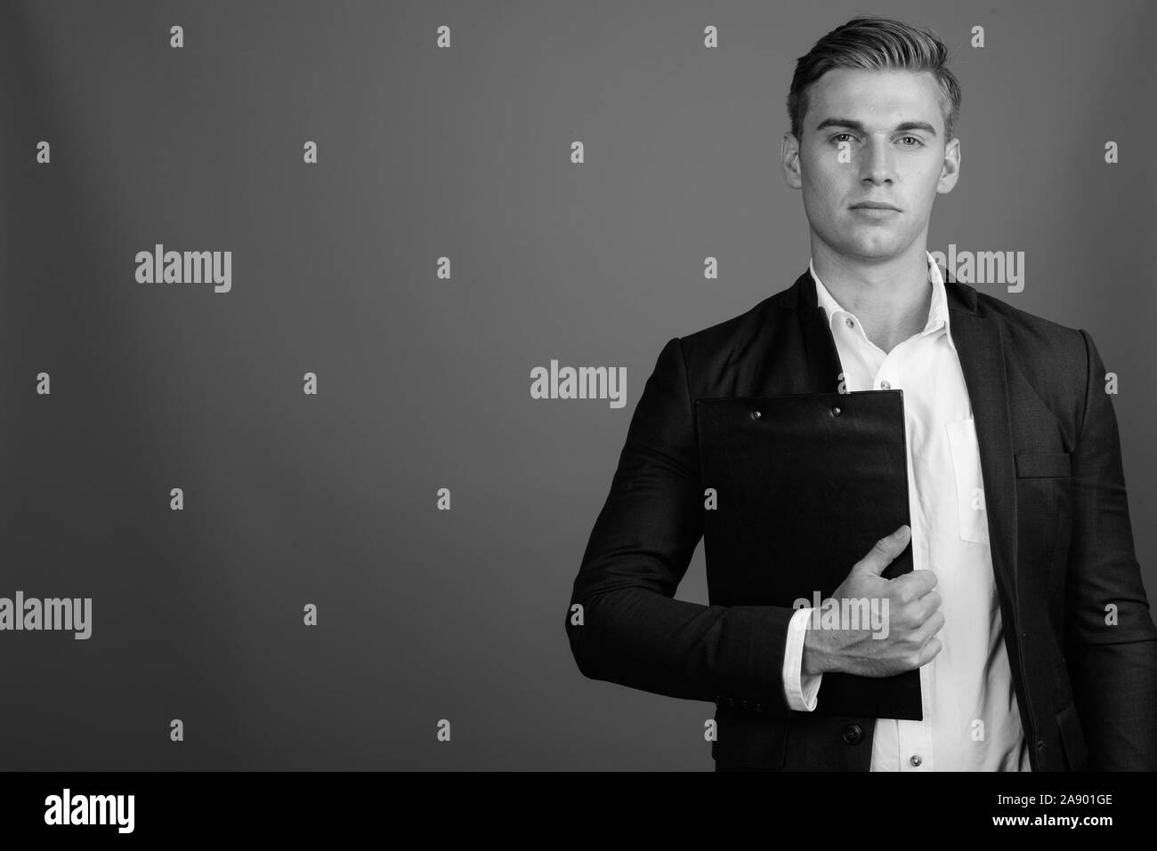 Portrait of young handsome businessman wearing suit in black and white ...