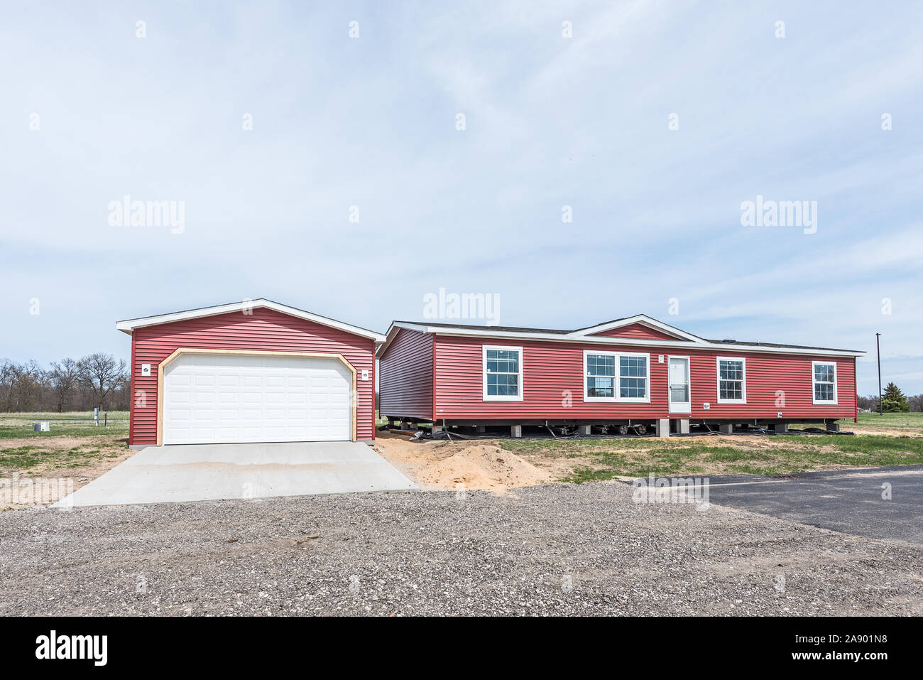 New manufactured home with red vinyl siding and windows with white