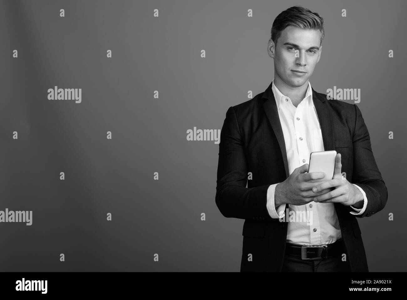 Portrait of young handsome businessman wearing suit in black and white ...