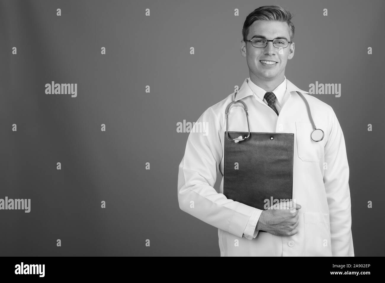 Doctor smiling holding clipboard Black and White Stock Photos & Images ...