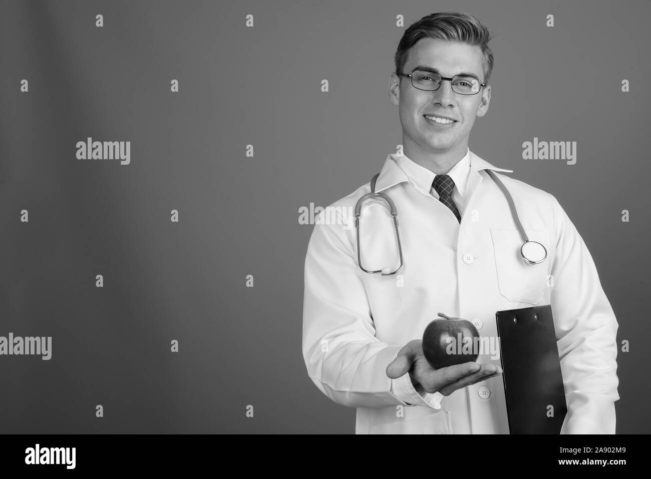 Doctor smiling holding clipboard Black and White Stock Photos & Images ...