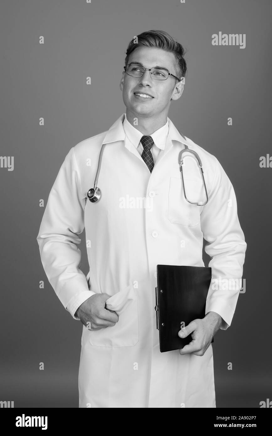 Doctor smiling holding clipboard Black and White Stock Photos & Images ...