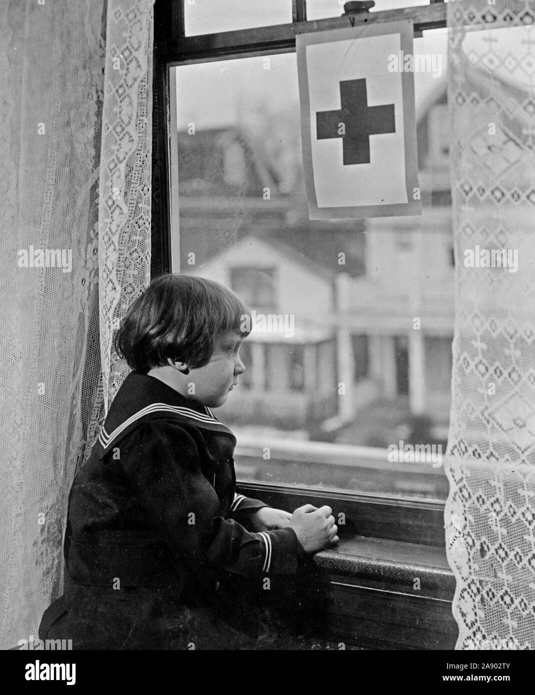 Red Cross - Little girl looking out window ca. 1910-1920 Stock Photo