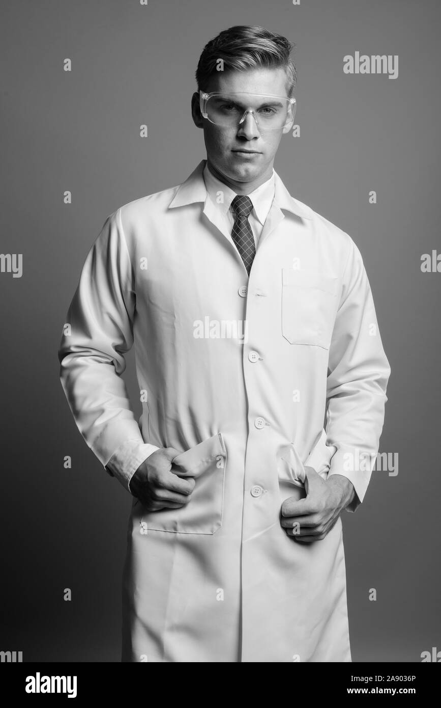 Portrait of young handsome man doctor as scientist in black and white Stock Photo