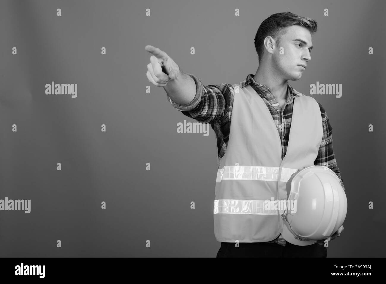 Profile view of young handsome man construction worker in black and white Stock Photo