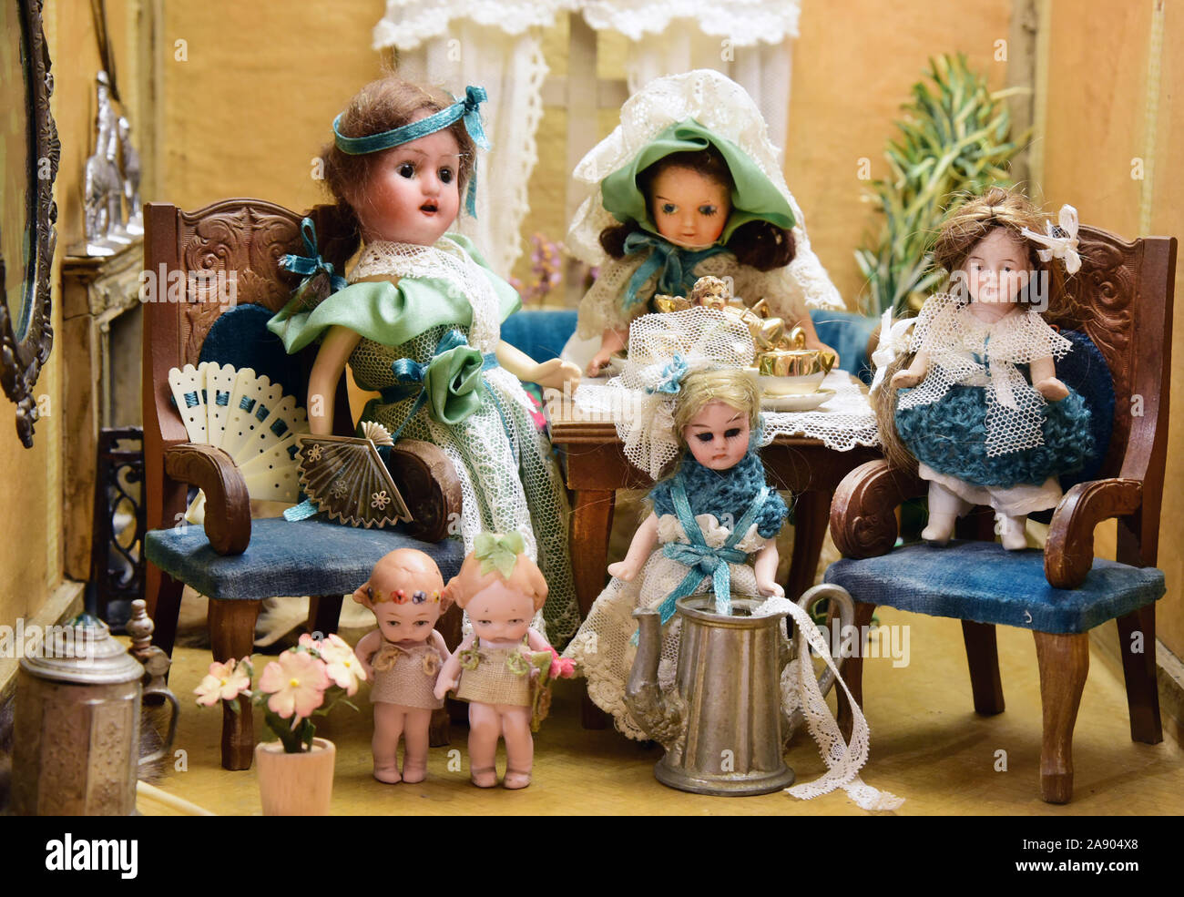 06 November 2020, Saxony, Delitzsch: In the Museum Barockschloss Delitzsch  the collector Hella Müller from Zwönitz is preparing a doll's house with  bisque head dolls from the time around 1898 for the