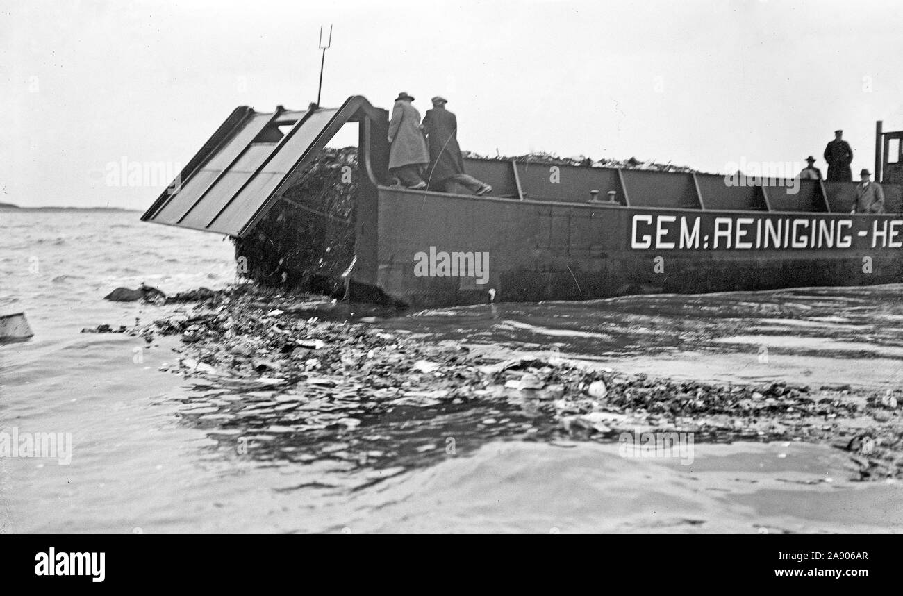 Netherlands History - Municipal cleaning garbage boat hopper dumps garbage into the sea ca. 1920 Stock Photo