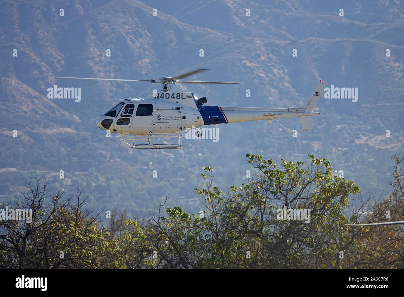 Sylmar, CA / USA - Nov. 9, 2019: A U.S. Customs and Border Protection helicopter, operated by the Dept. of Homeland Security, is shown flying low. Stock Photo