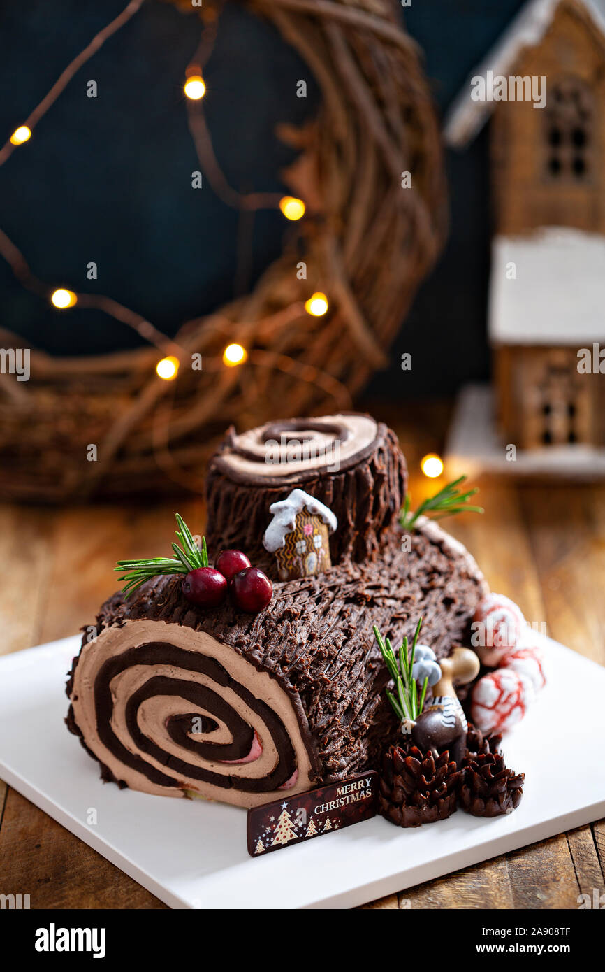 Christmas Yule log cake with edible sweet mushrooms and pine cones