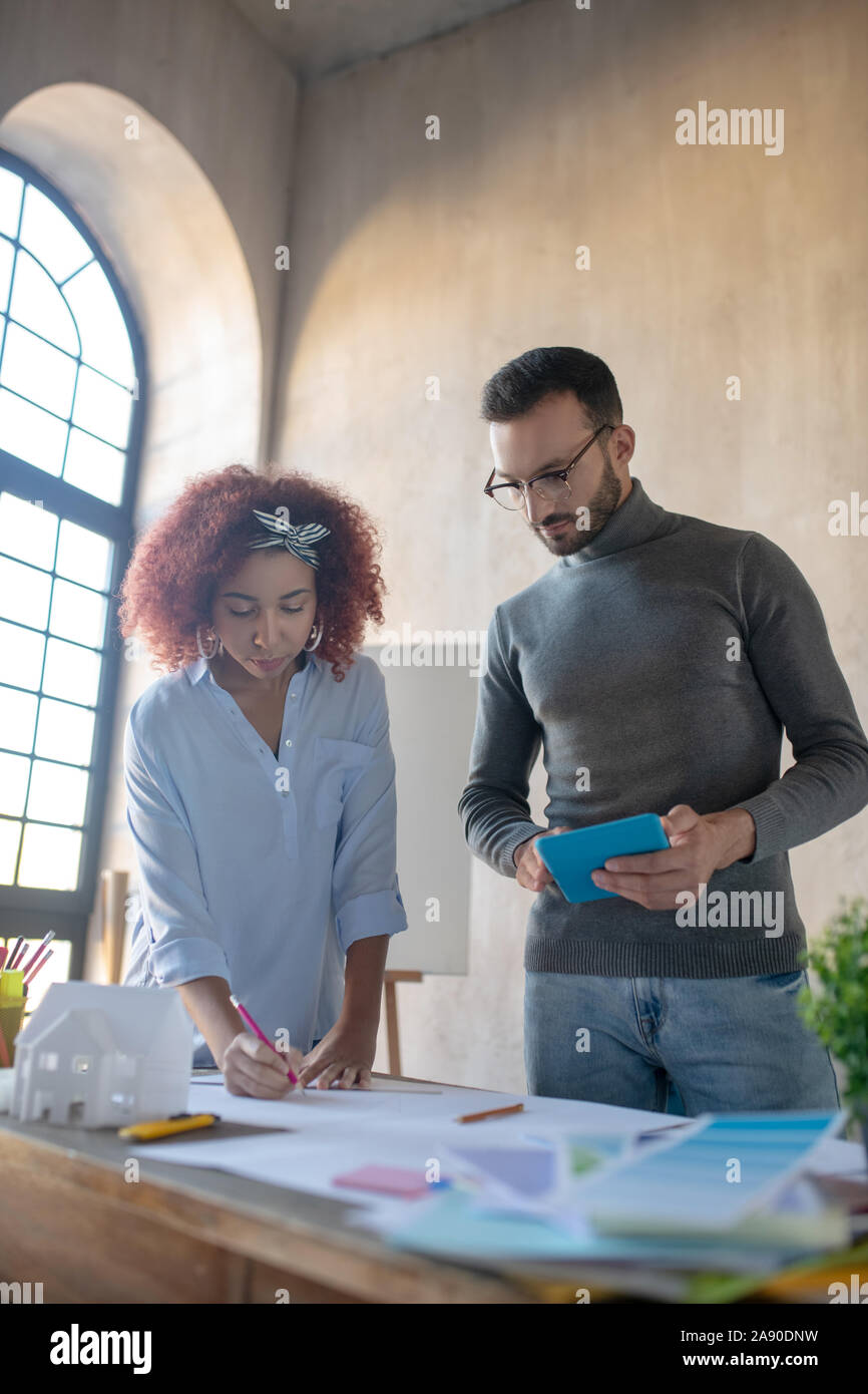 Interior designer holding tablet working with colleague Stock Photo