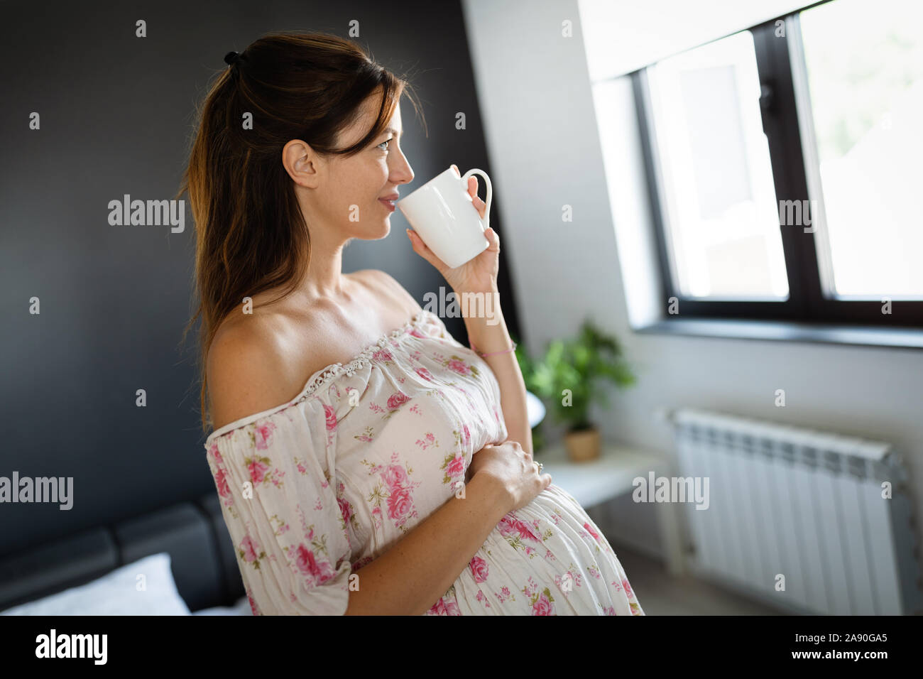 Young pregnant woman at home sipping tea from a cup Stock Photo - Alamy