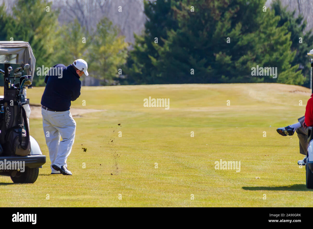 A golfer hitting a golf ball on the fairway. Stock Photo
