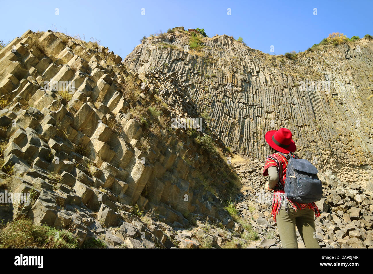 Woman Impressed by the Incredible Symphony of Stones Basalt Column Formations Along the Garni Gorge, Armenia Stock Photo