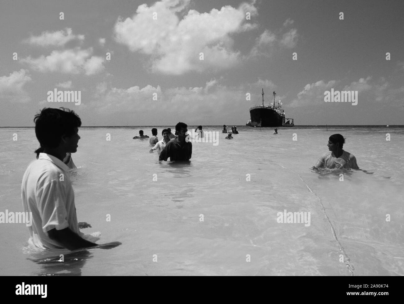 Maledives: Local people pulling a old freight ship to the coast to sink it and cultivate a coral reef Stock Photo