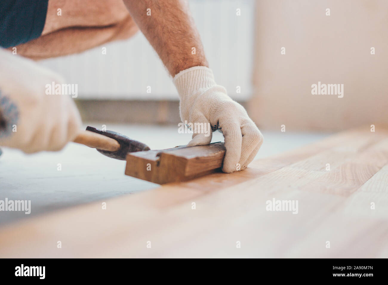 The master hammers the boards closer with a hammer repair and