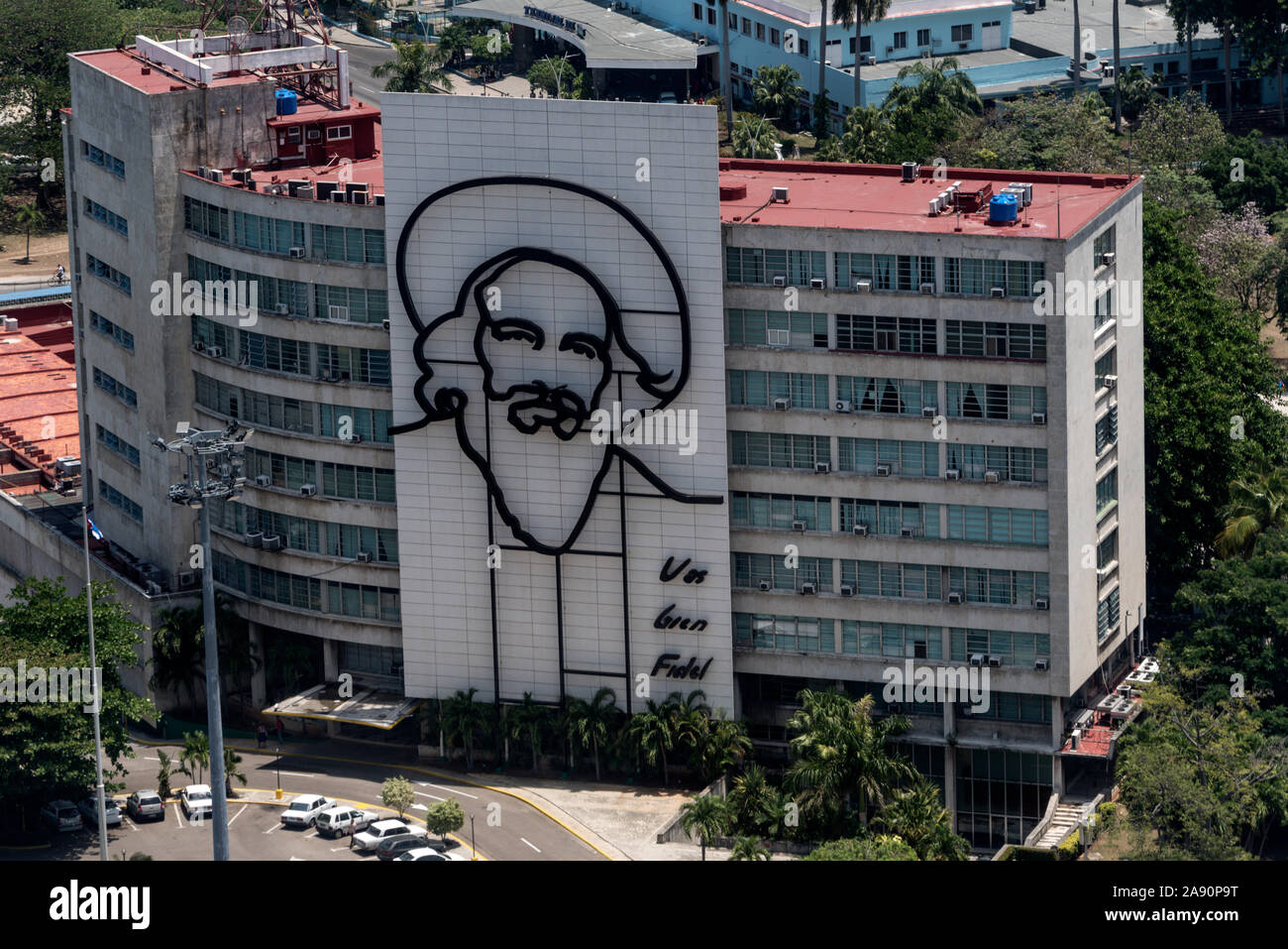On the wall of the Cuban Ministry of Communications - Cubano Ministerio de Comunicaciones, is a large portrait of Cuban Revolution leader, Camilo Cien Stock Photo