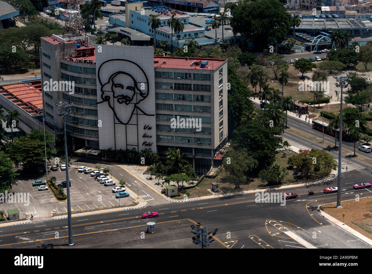 On the wall of the Cuban Ministry of Communications - Cubano Ministerio de Comunicaciones, is a large portrait of Cuban Revolution leader, Camilo Cien Stock Photo