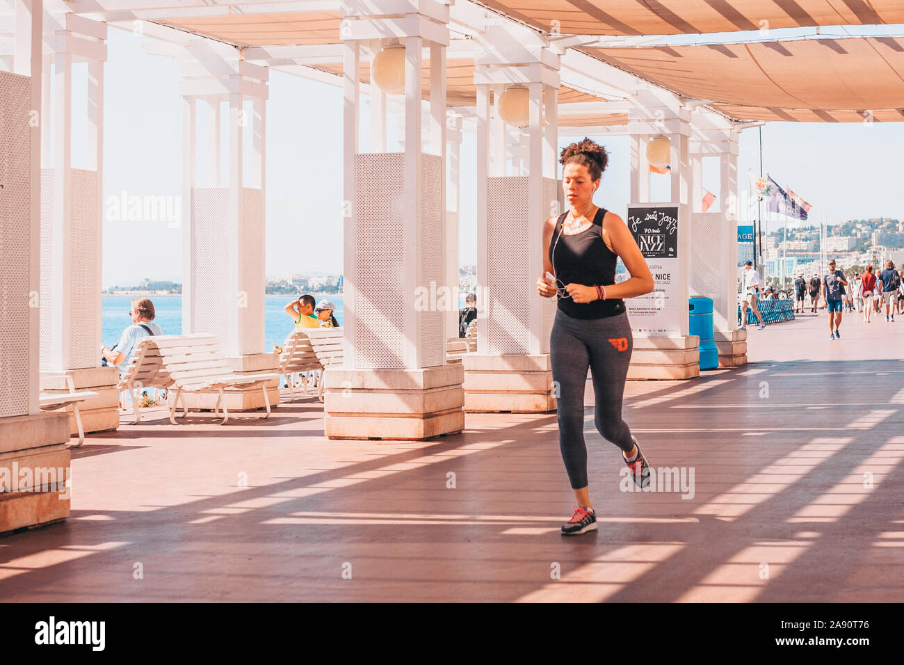 Nice, Provence / France - September 29, 2018: Young slim sporty woman runs along the promenade Stock Photo