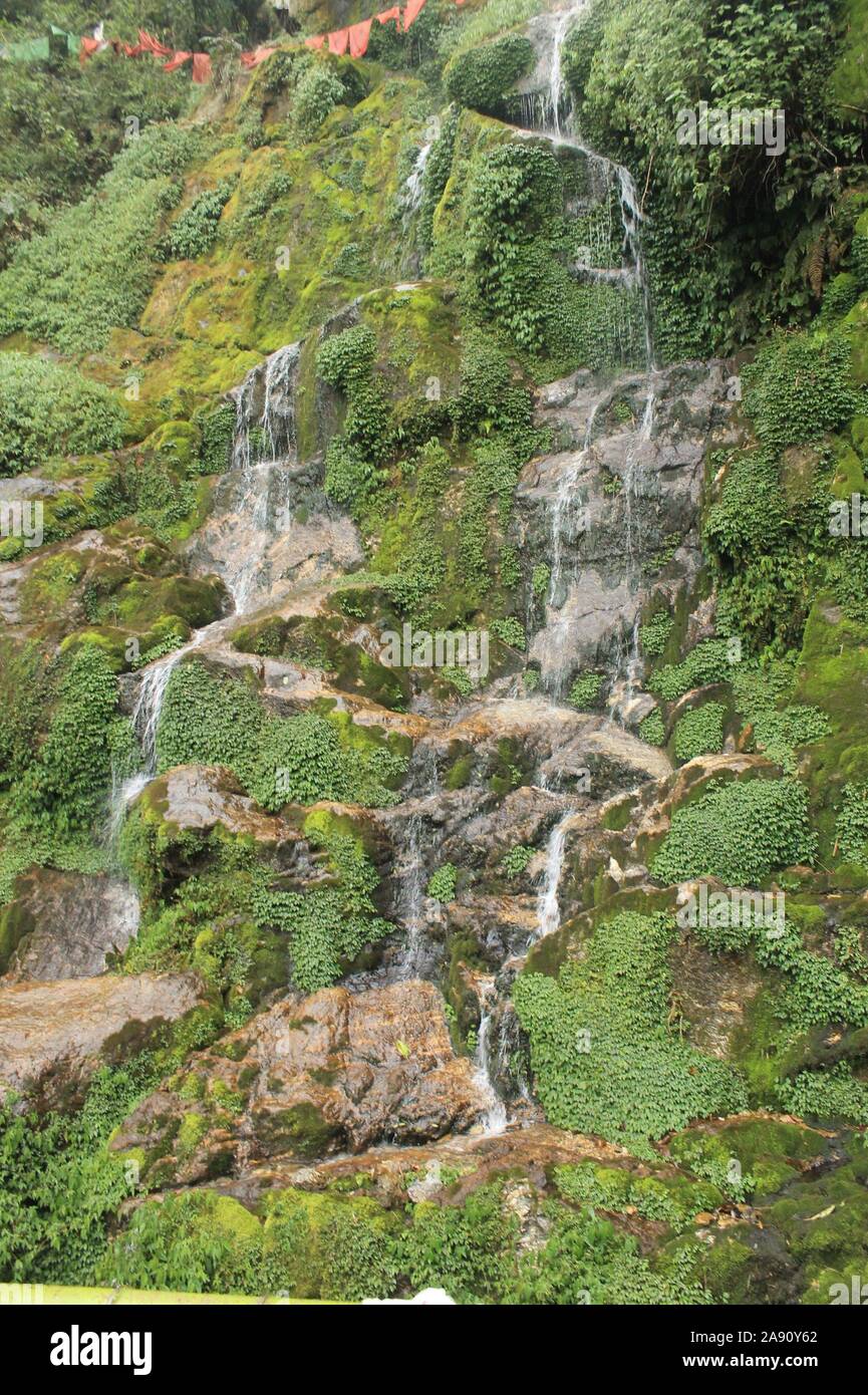 A small waterfall by the hillside. Stock Photo
