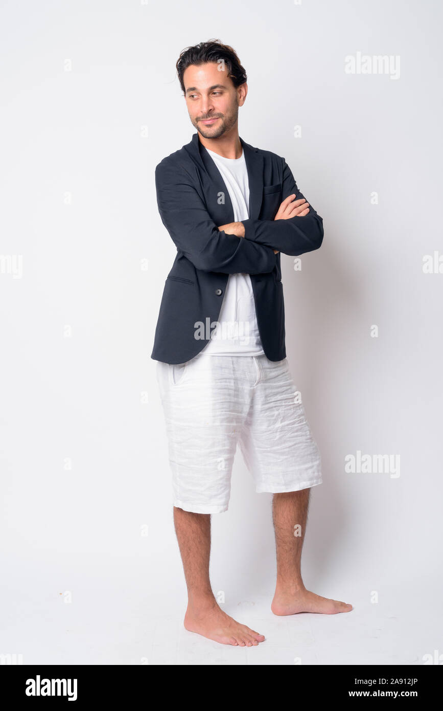 Full body shot of handsome Hispanic businessman thinking with arms ...