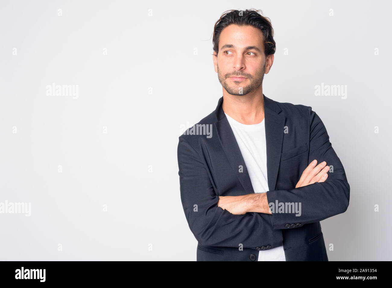 Portrait of handsome Hispanic businessman thinking with arms crossed ...