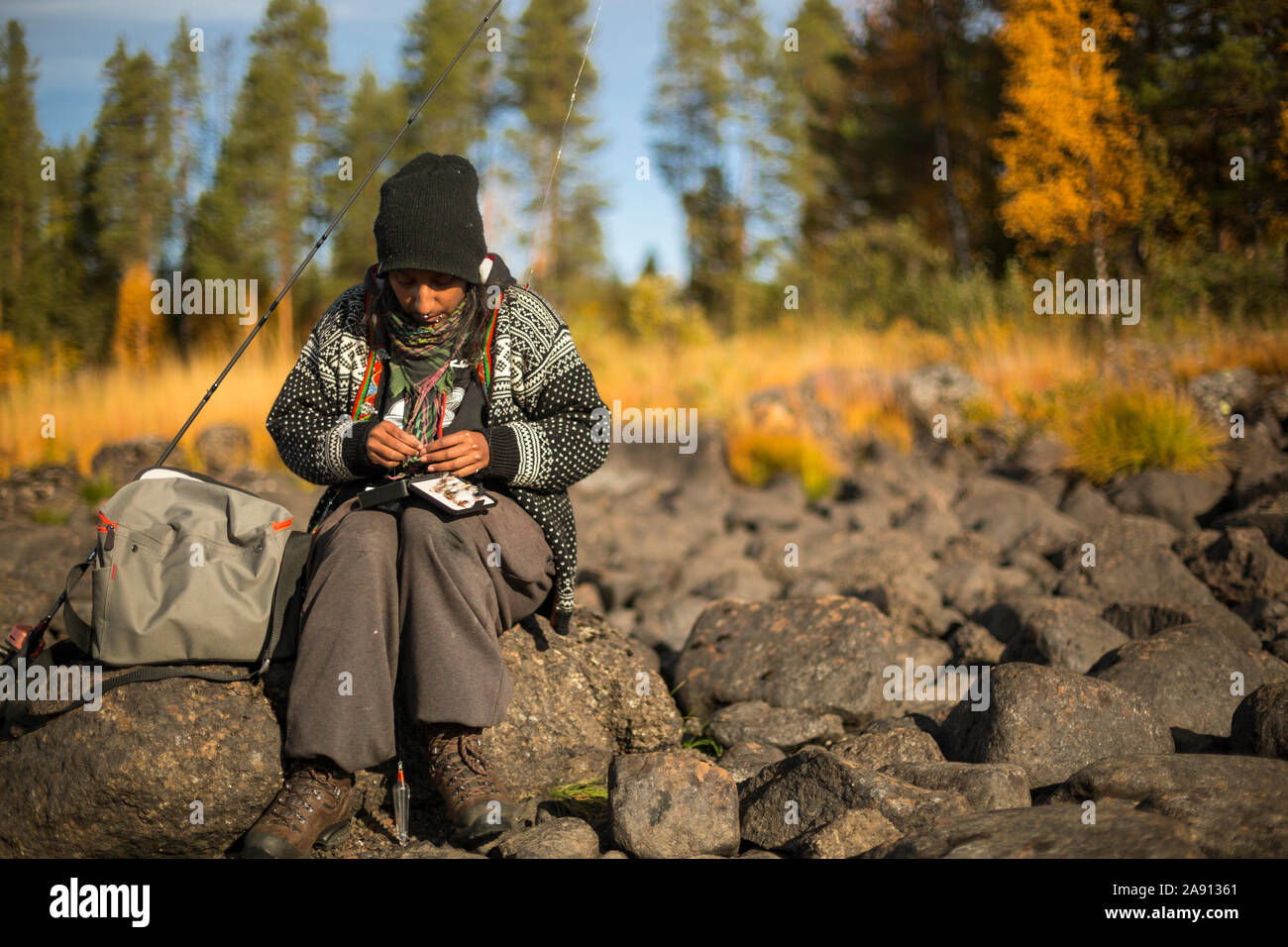 Woman sitting on rocks hi-res stock photography and images - Alamy