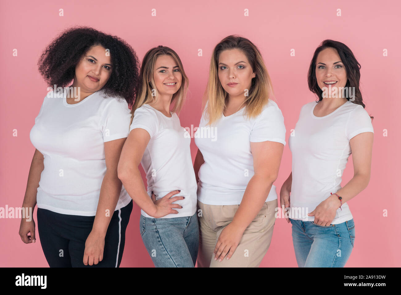 Two plus-size models and two skinny girls in white t-shirts. Design on white women's t-shirts Stock Photo