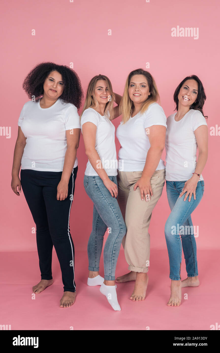 Two plus-size models and two skinny girls in white t-shirts. Design on white women's t-shirts Stock Photo