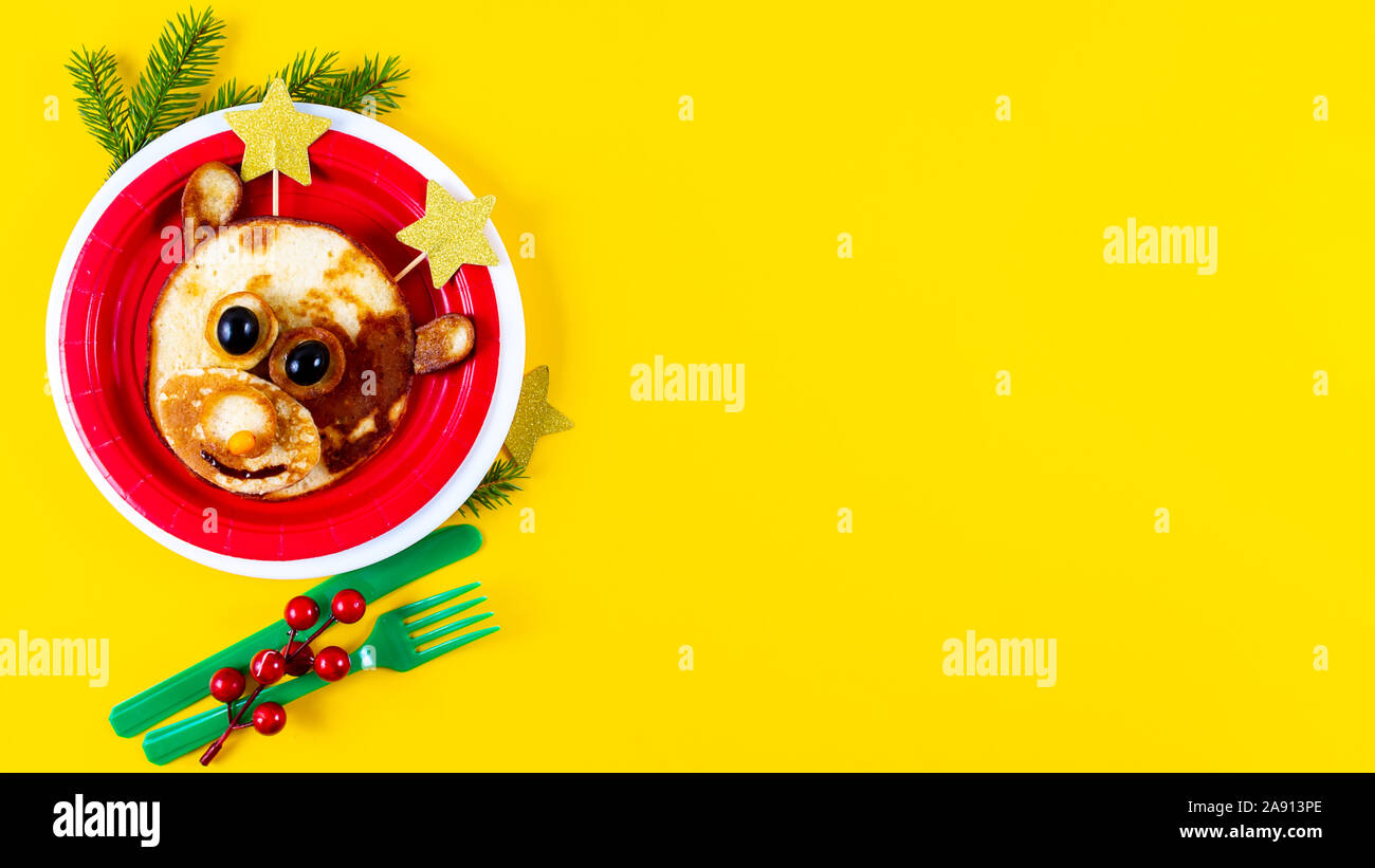 Creative Christmas food art. Edible deer on red plate with star instead