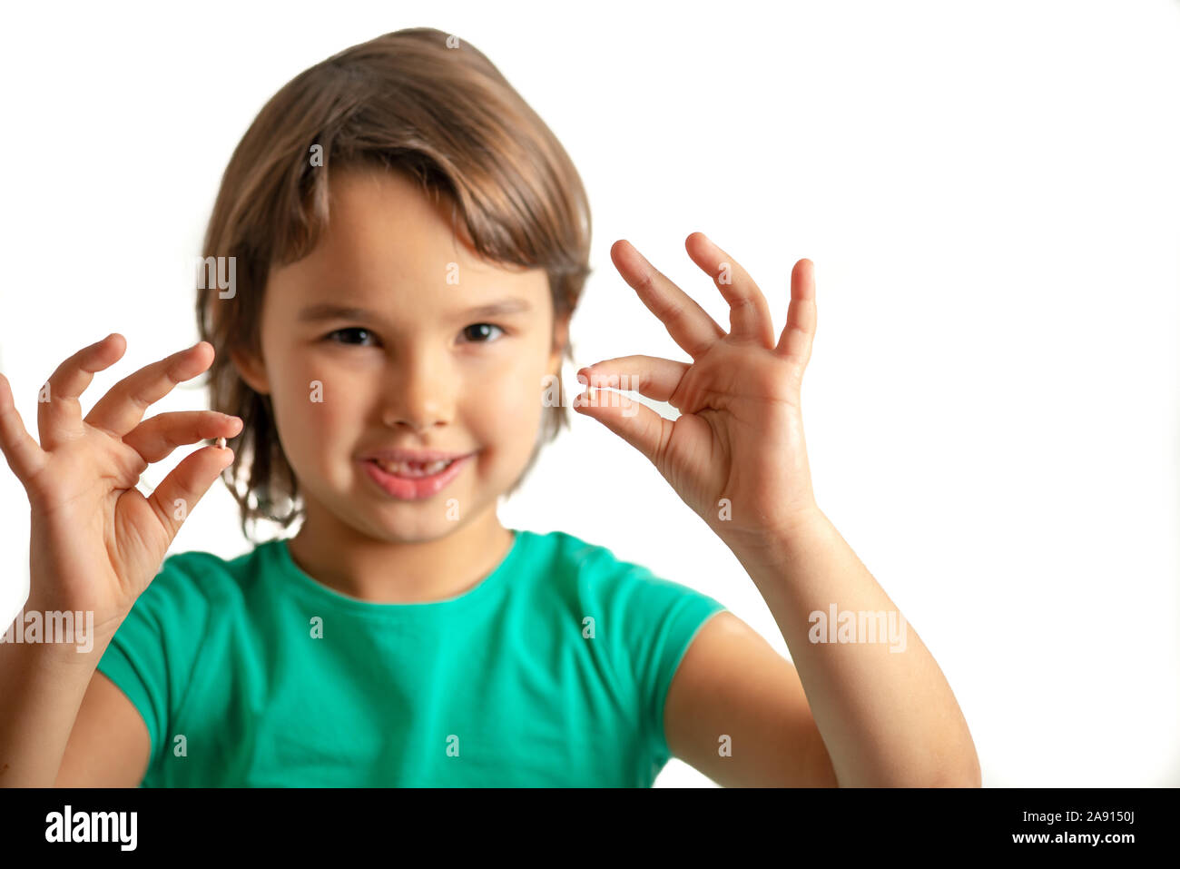 Girl with tooth in hands on isolated white background. Happy and proud Stock Photo