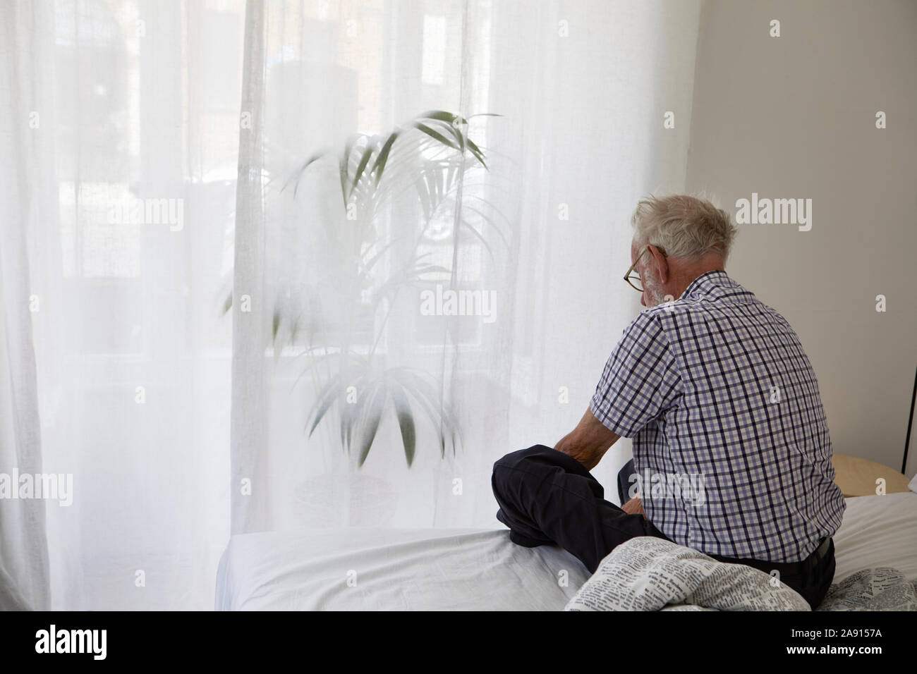 Man sitting on bed Stock Photo