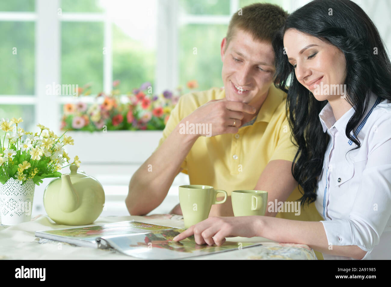 Portrait of happy young couple reading interesting book Stock Photo