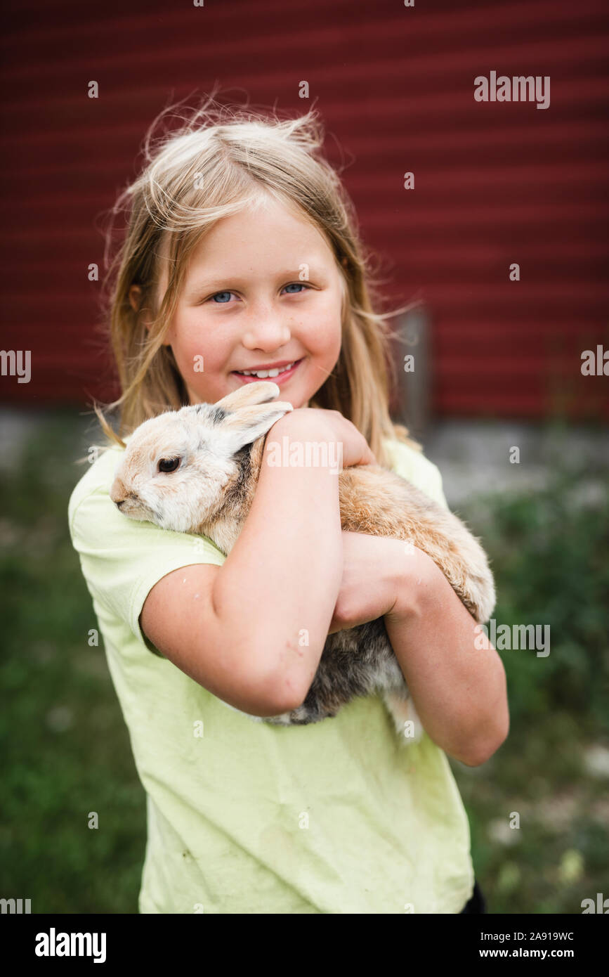 Girl holding rabbit Stock Photo - Alamy