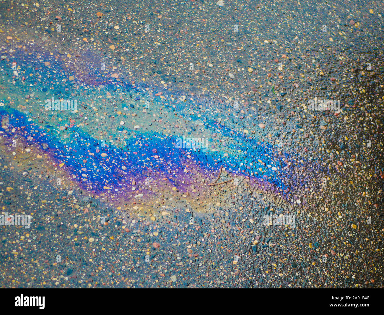A puddle of gasoline on the pavement. Closeup. Gasoline that had