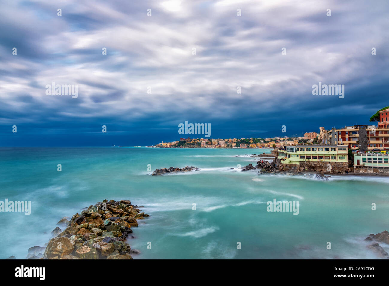 Picturesque view of the Italian coastline with colorful waterfront buildings overlooking the Mediterranean on an overcast cloudy blue sky day Stock Photo