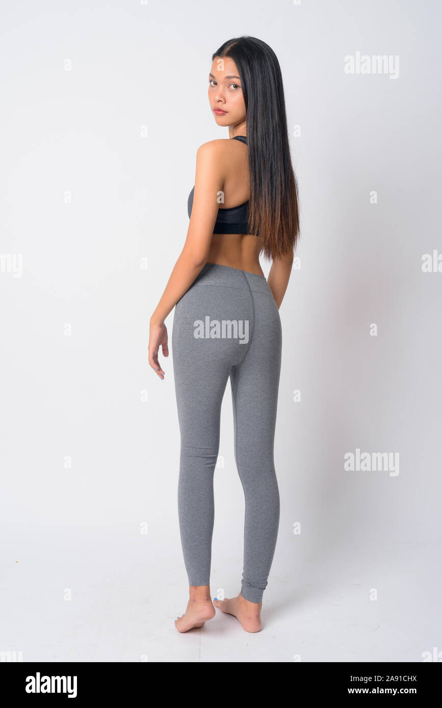 Full body shot rear view of young Asian woman looking over shoulder ready for gym Stock Photo