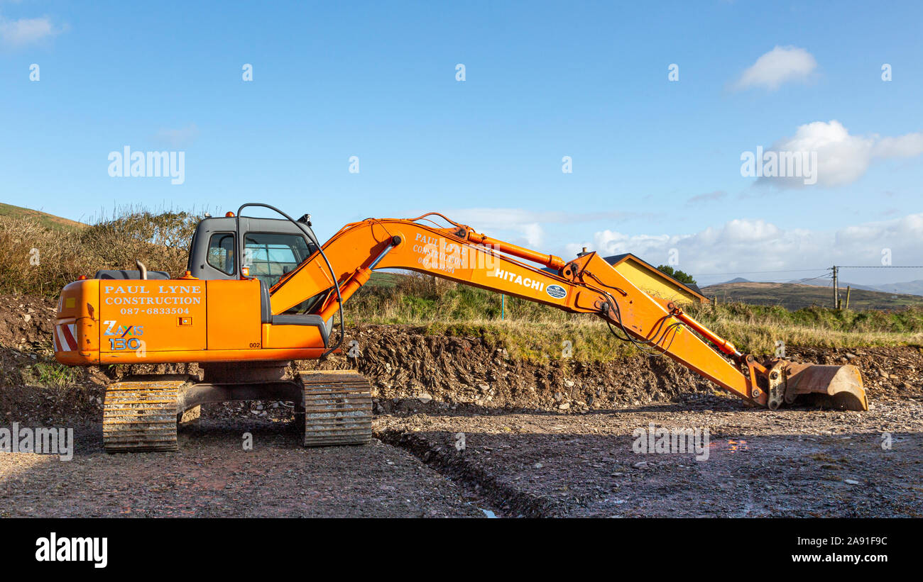 Excavating soil at the back of private house with bulldozer, to level the ground for drainage Stock Photo