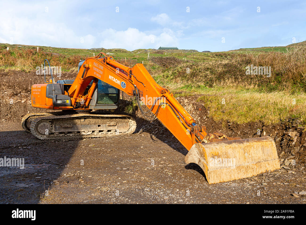 Excavating soil at the back of private house with bulldozer, to level the ground for drainage Stock Photo