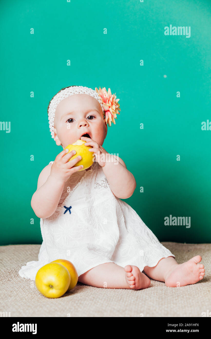 baby girl in a dress with Green apples Stock Photo Alamy