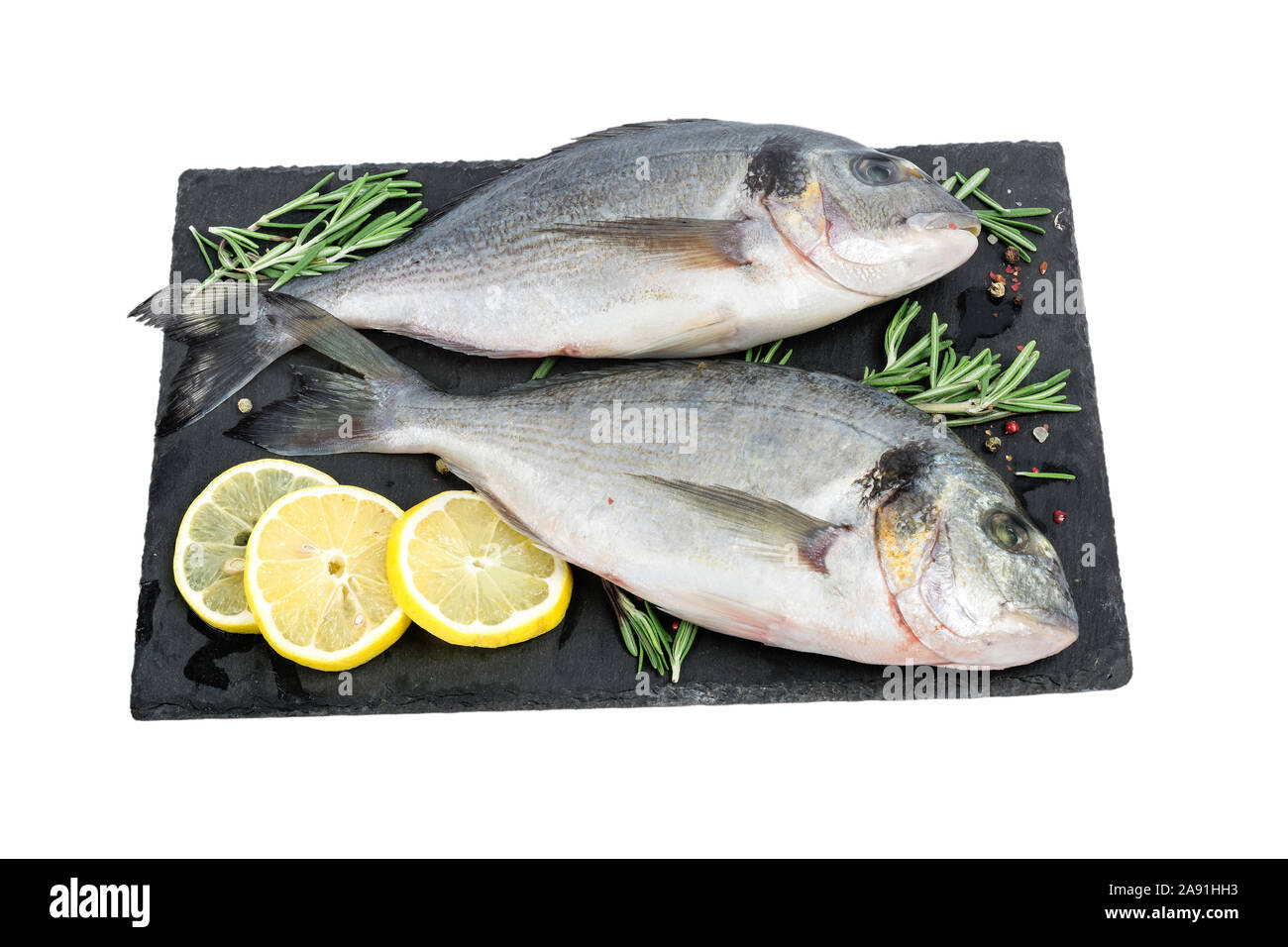 Fresh fish dorado or sea bream. Raw fish seabass with spices and herbs ingredients for cooking isolated on white background. healthy diet food Stock Photo