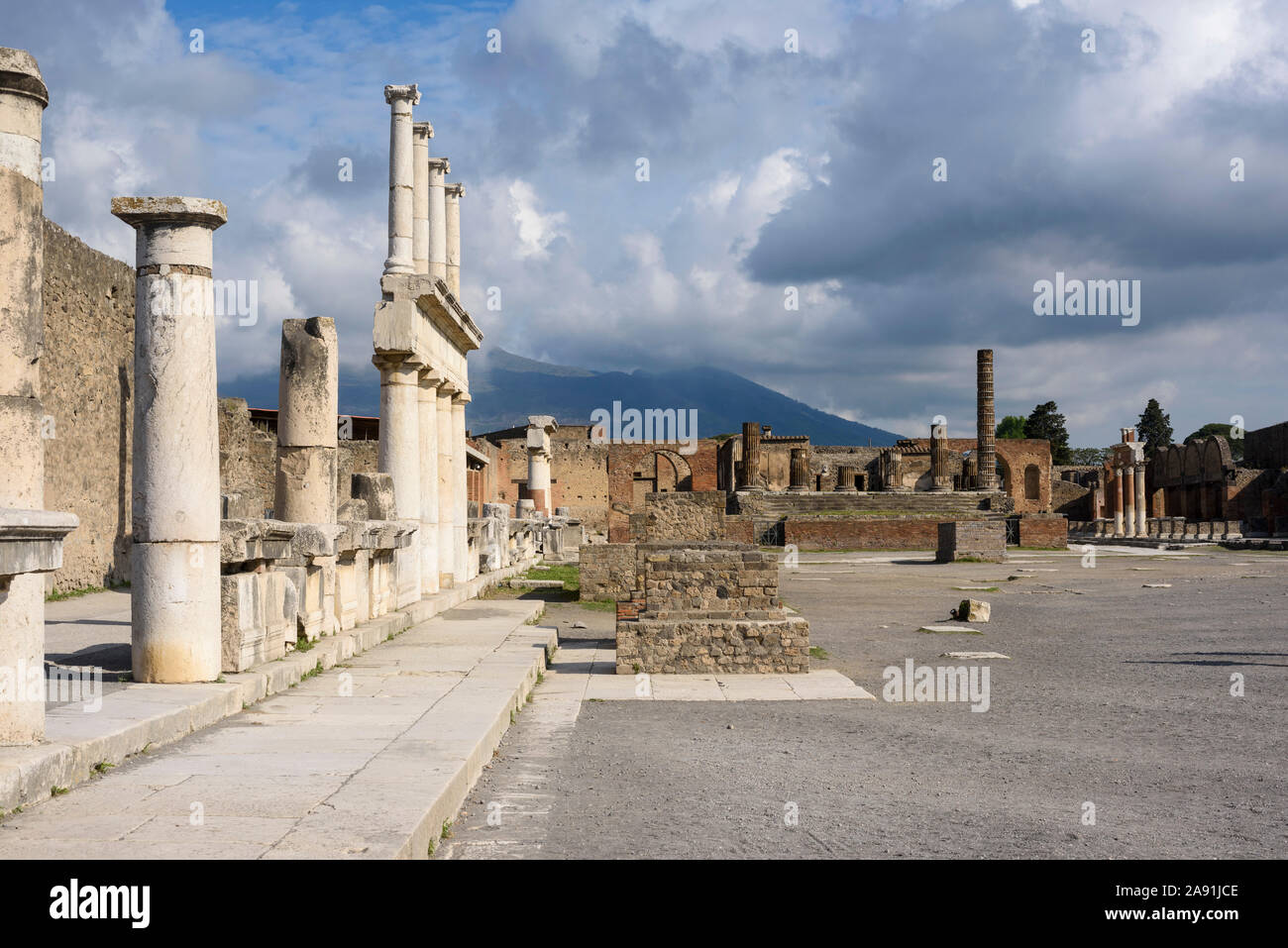 Pompei. Italy. Archaeological site of Pompeii. View of the Civil Forum (Foro Civile), towards the Capitolium, with Mount Vesuvius in the background. O Stock Photo