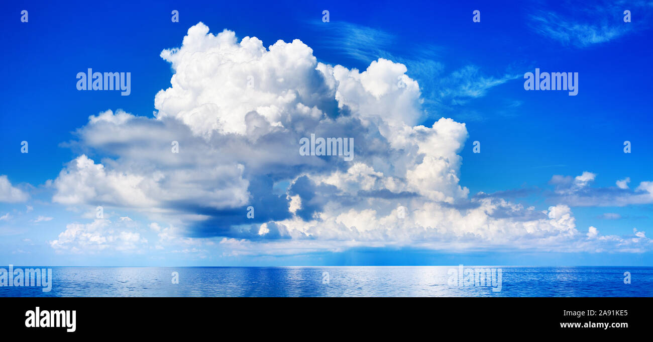 White cumulus clouds in blue sky over sea landscape, big cloud above ...