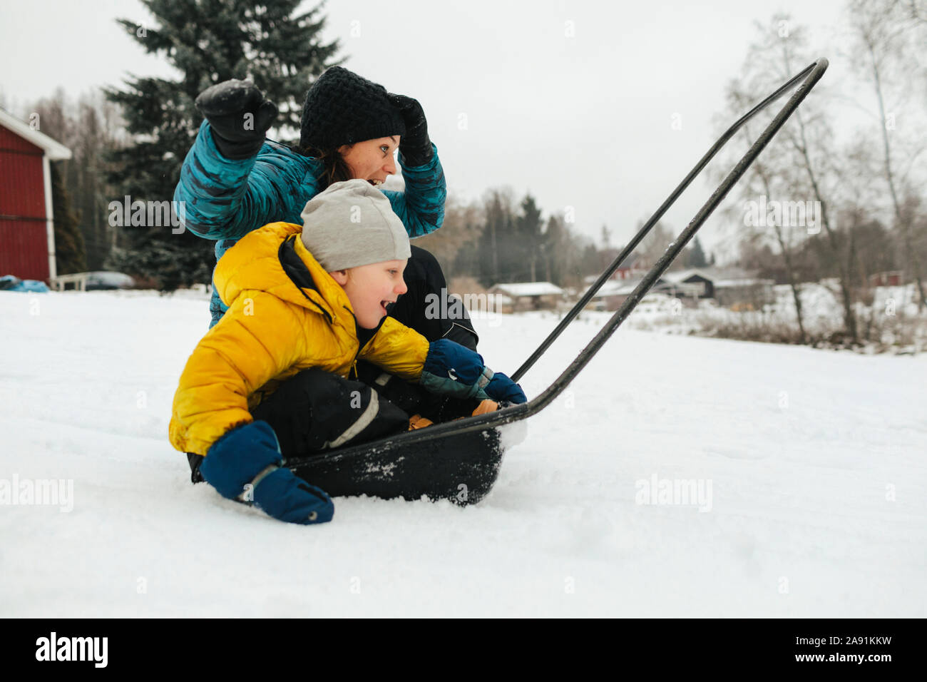 Mother with son on sleigh snow shovel Stock Photo Alamy