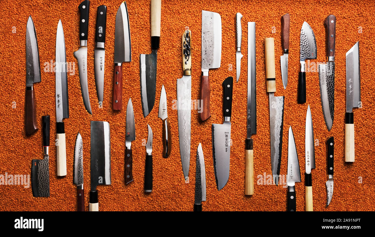 Kitchen knives on orange background Stock Photo