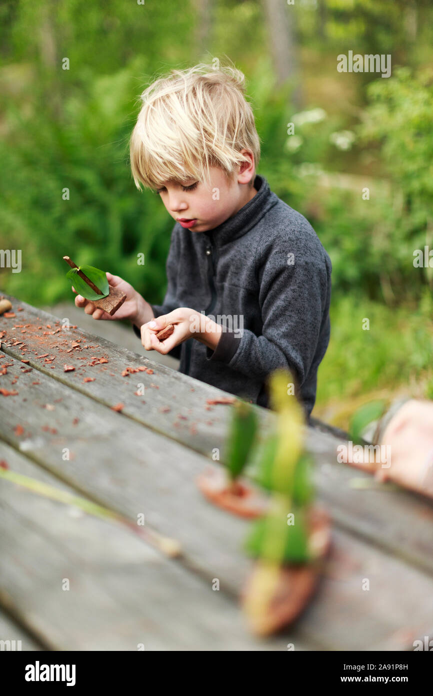 Boy playing with wooden boats Stock Photo