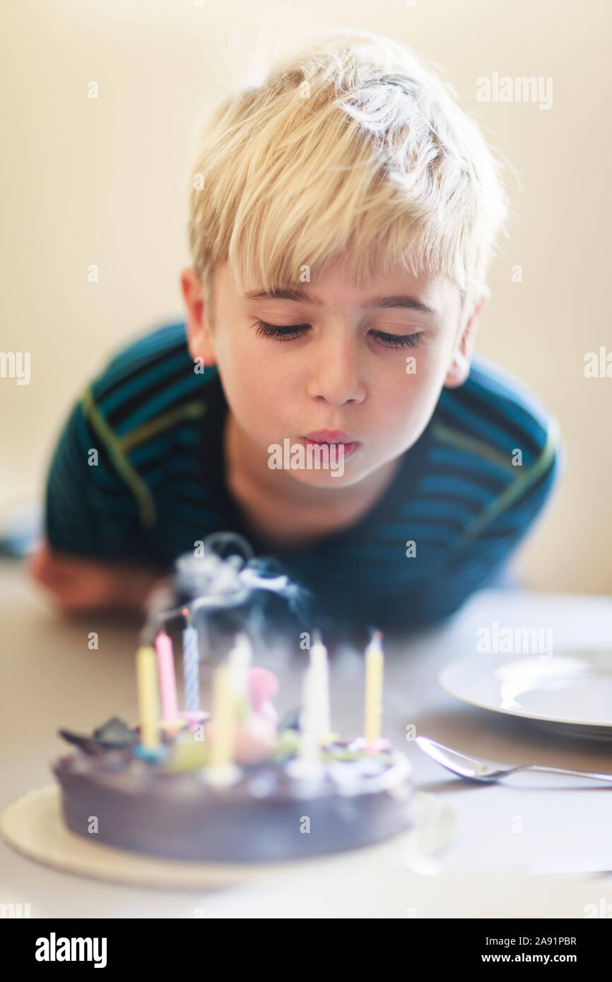 Boy blowing birthday candles Stock Photo Alamy