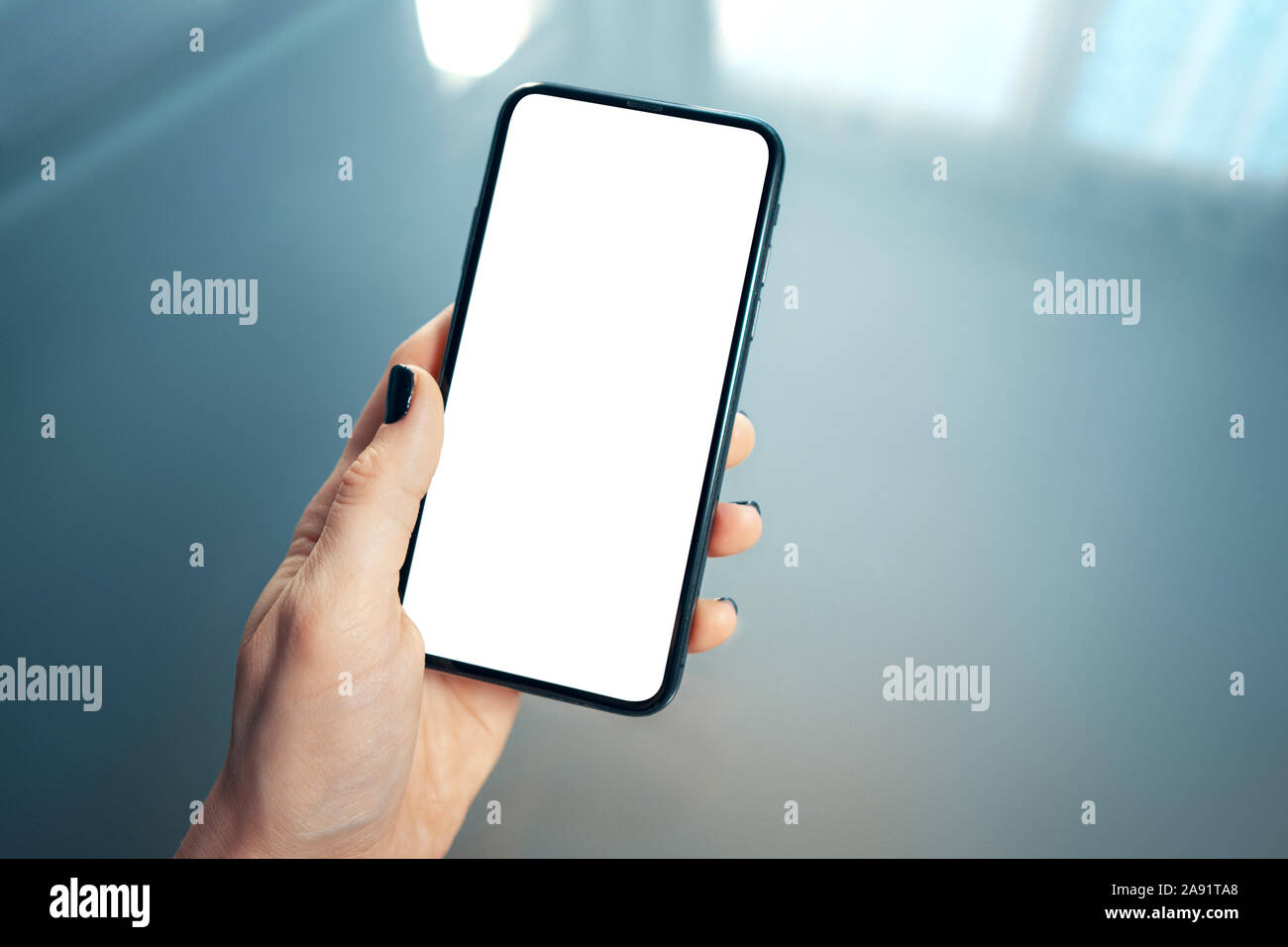 Close up of women's left hand holding modern mobile phone with blank ...